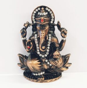 Image of a copper shaded Car dashboard Idol of Lord Ganesha