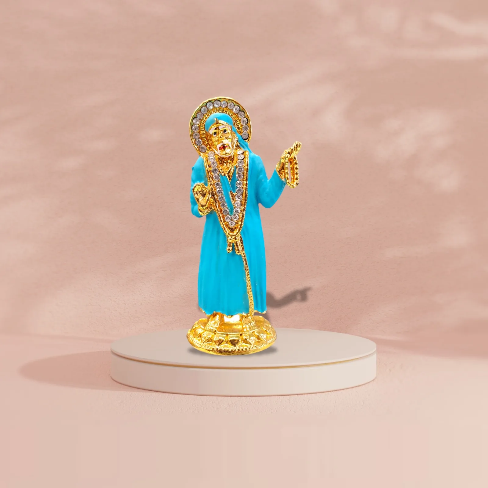 Buy Sai Baba car dashboard idol in Canada and US. Blue Sai Baba idol on a pink background.