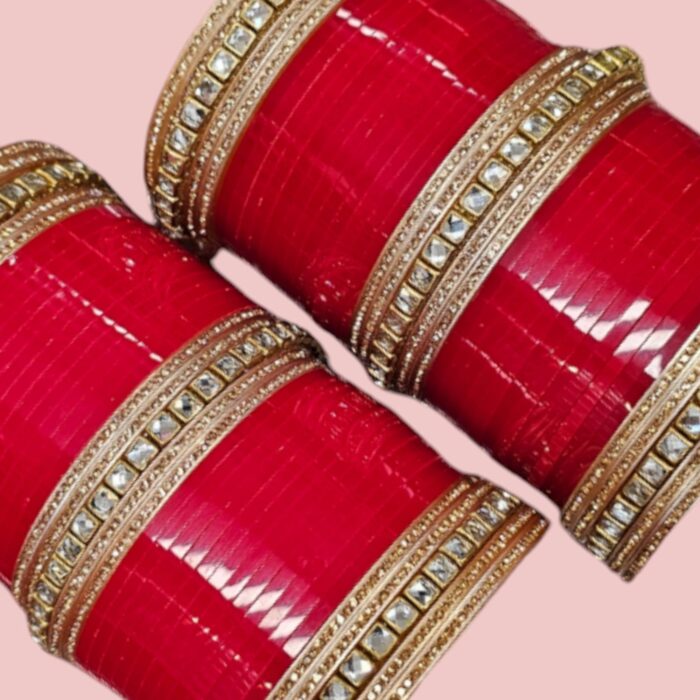 Designer Red Chura with rose-gold gemstones on a pink background.