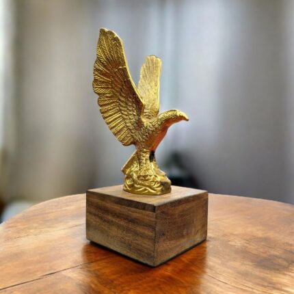 Close-up of detailed brass eagle sculpture showing textured feathers and sharp talons.