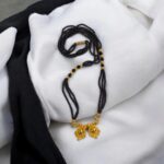 Close-up of the Two Wati pendant and triple-strand black beads on the Mangalsutra chain.