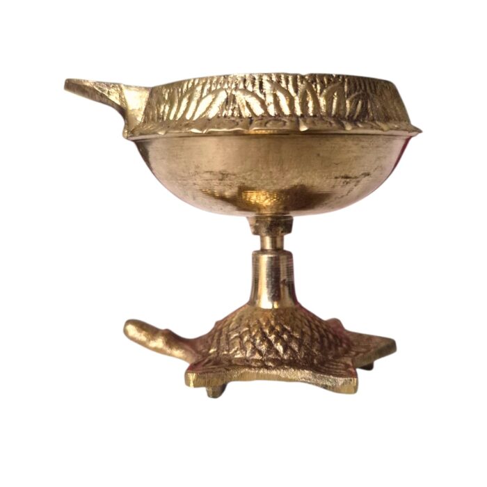 Side profile view of brass kuber diya with a tortoise base