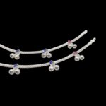 Close up of silver anklets with trinkets
