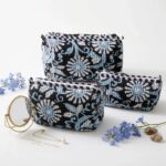 Three nesting black cotton travel pouches with traditional Indian block print