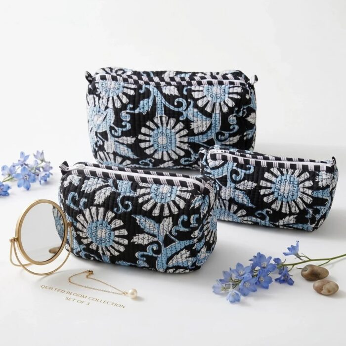 Three nesting black cotton travel pouches with traditional Indian block print