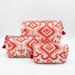 Three nesting red cotton travel pouches showing size variation: large, medium, small
