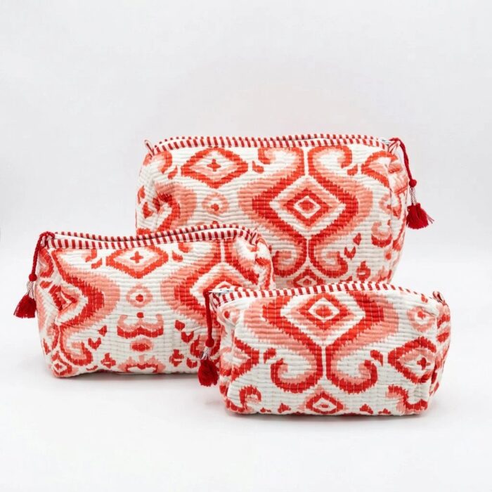 Three nesting red cotton travel pouches showing size variation: large, medium, small