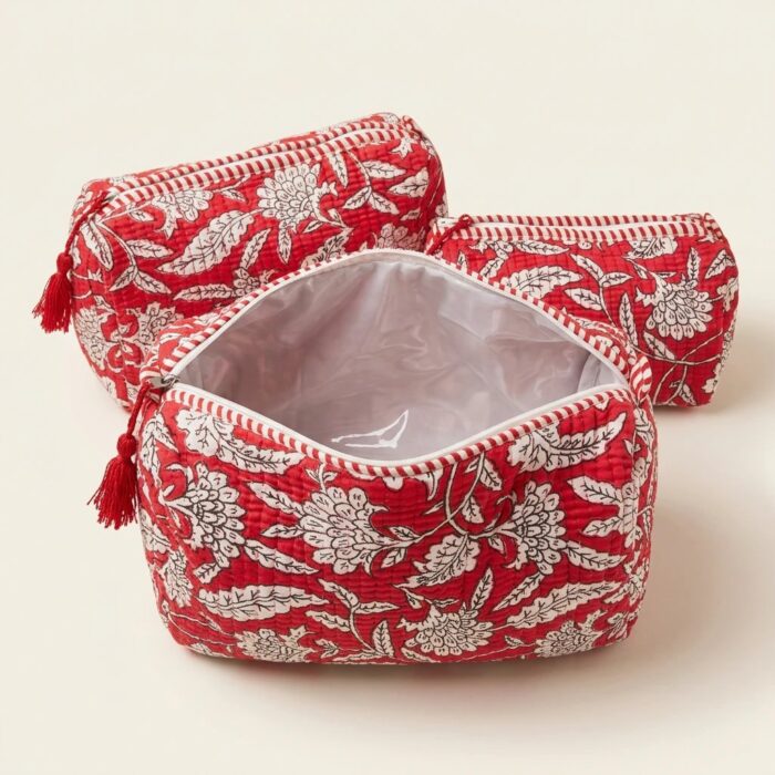 Close-up of red quilted cotton travel pouch showing traditional Indian block print and zipper
