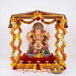 24 inch gold metal Ganpati makhar frame decorated with marigold garlands and a home Ganesh idol