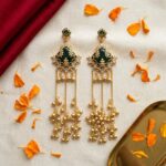 Pair of green onyx Kashmiri ghungroo earrings standing on emerald silk