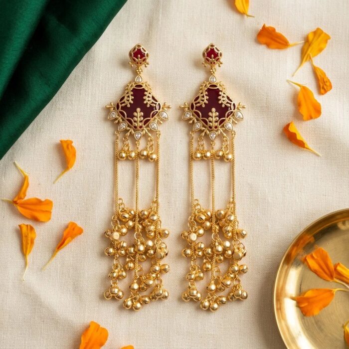 Maroon onyx Kashmiri ghungroo earrings flat lay on ivory linen with marigold petals, brass tray and emerald silk fold