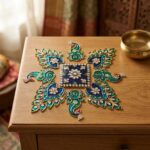 Separate peacock-inspired metal rangoli pieces styled on a modern tabletop.