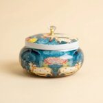 Pichwai cow dry fruit jar with crystal knob lid on beige background