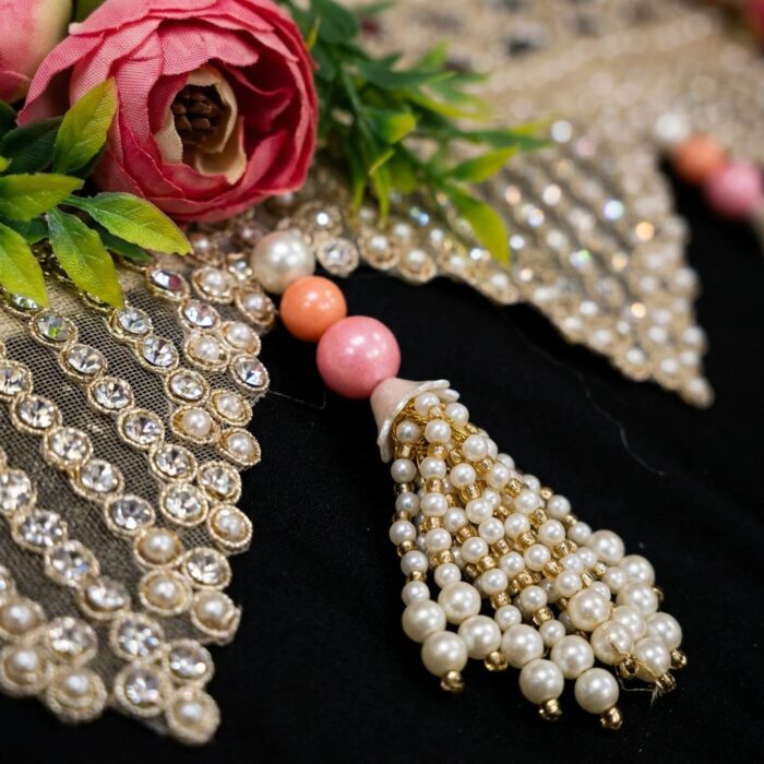 Macro detail of blush rose bandhanwar — pearl and clear stone point fringe, faux pearl tassel and pink peach beads with fabric rose