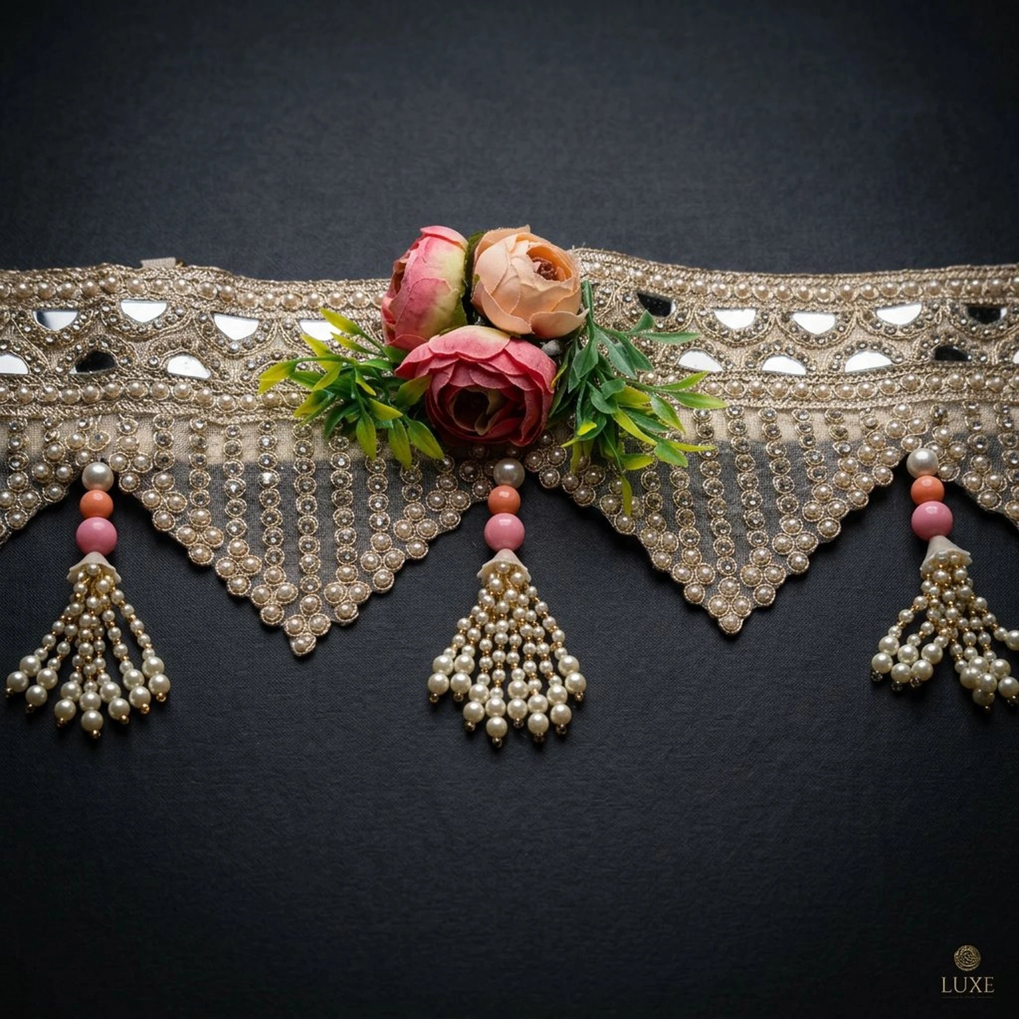 Close up of the Toran Close view of gold mirror toran on black — blush rose cluster, triangular pearl and crystal fringe and pearl tassel with pink beads