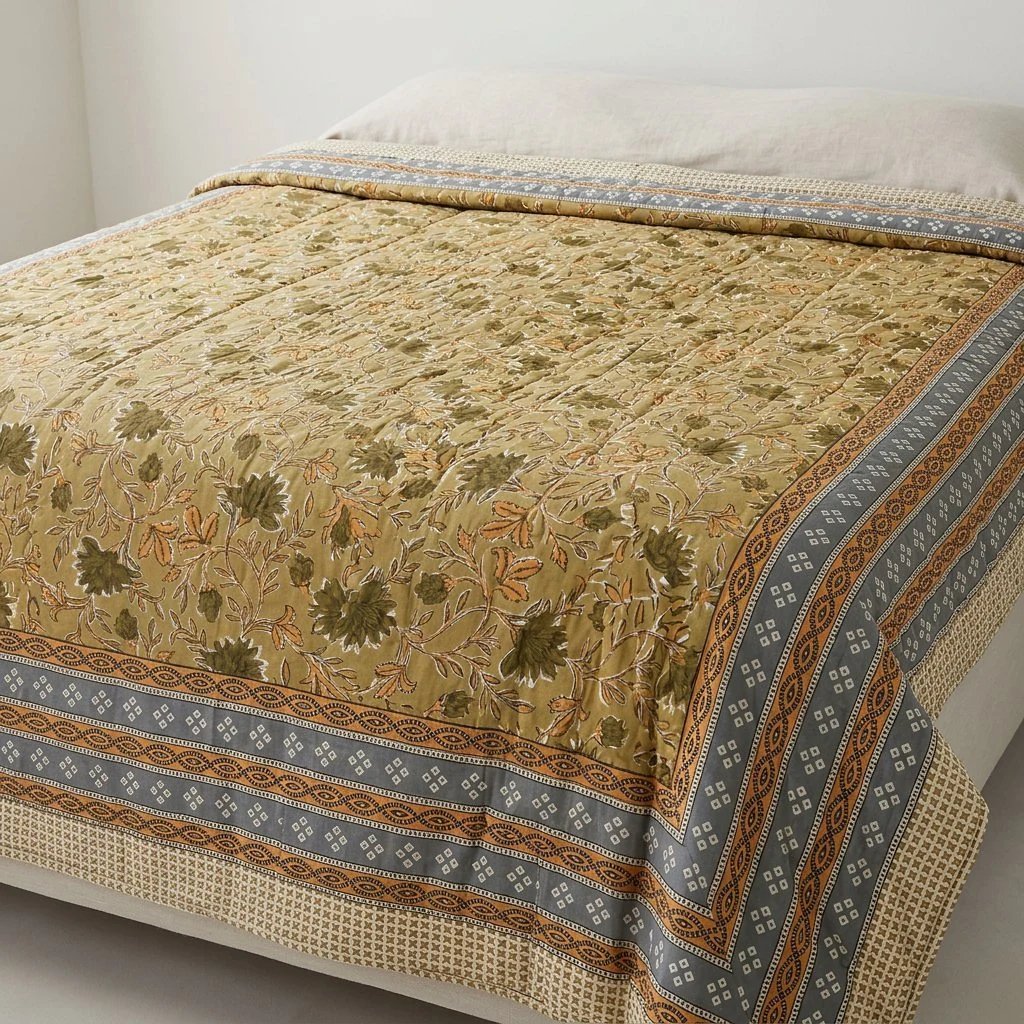 Yellow Botanical Print Jaipur hand block-printed cotton Razai quilt spread across a bed in yellow botanical print