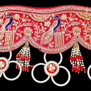 Close up of red gota patti toran peacock embroidery gold zari sequins pearl medallion and red bead tassel