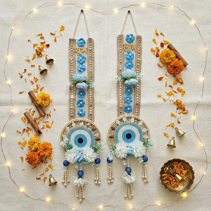 Shubh Labh pair flat-lay with marigolds, cinnamon, brass diya and fairy lights for Diwali decoration