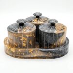 Real gold foil flakes suspended inside translucent hand-poured resin jar with vertical fluting and starburst lid knob